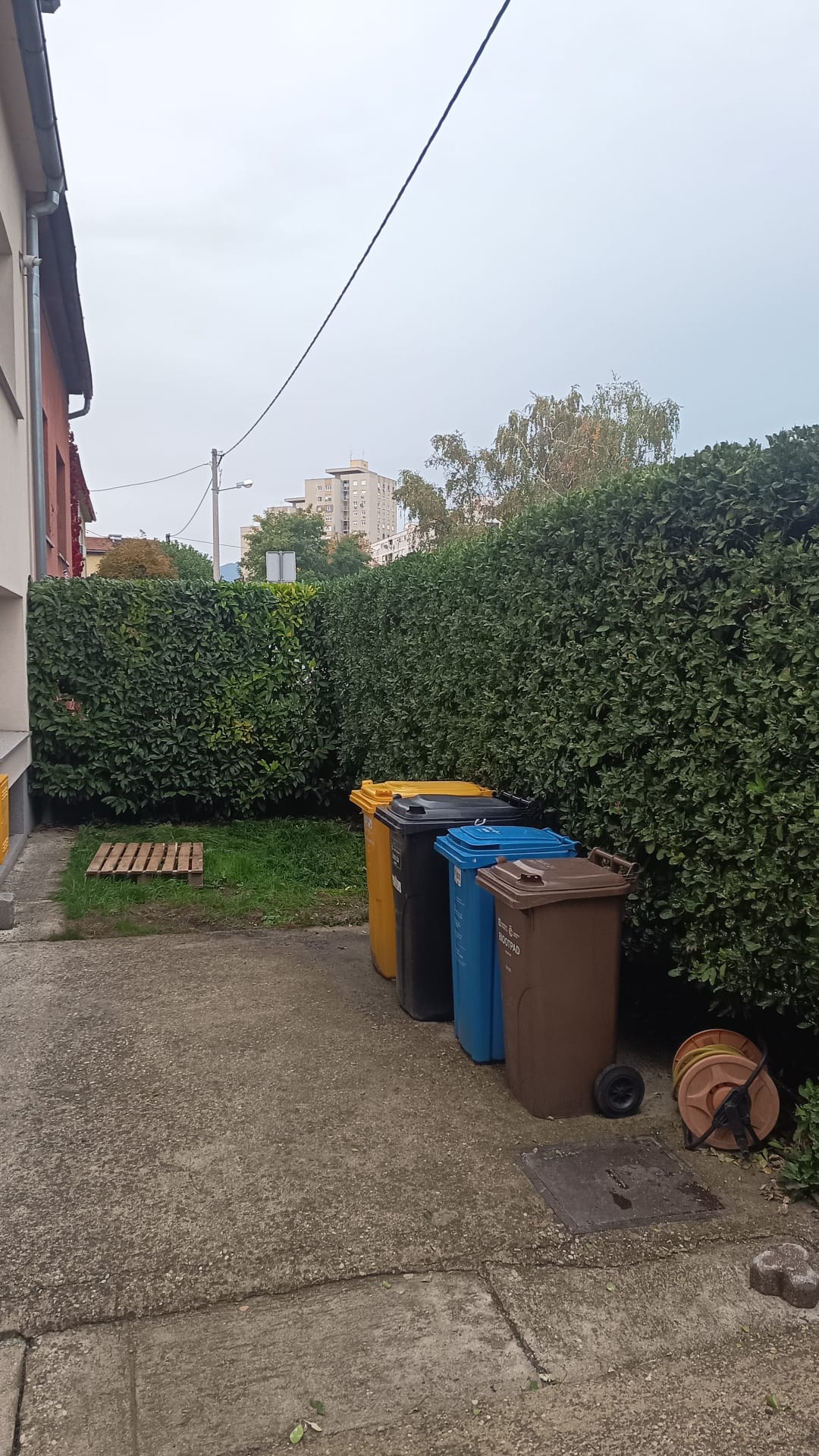 Podšišana živica i kante za otpad uz stazu u zagrebačkom dvorištu